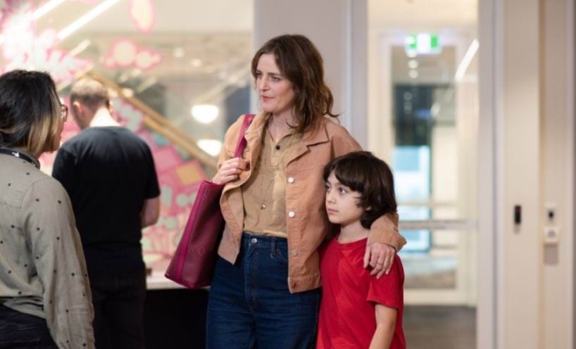 Two adults and a child standing and talking inside Two adults and a child standing and talking inside