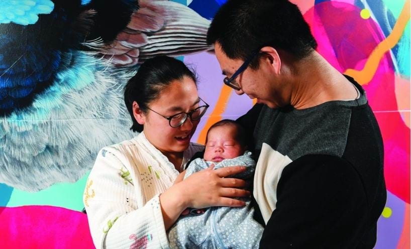 Two parents holding a newborn child Two parents holding a newborn child