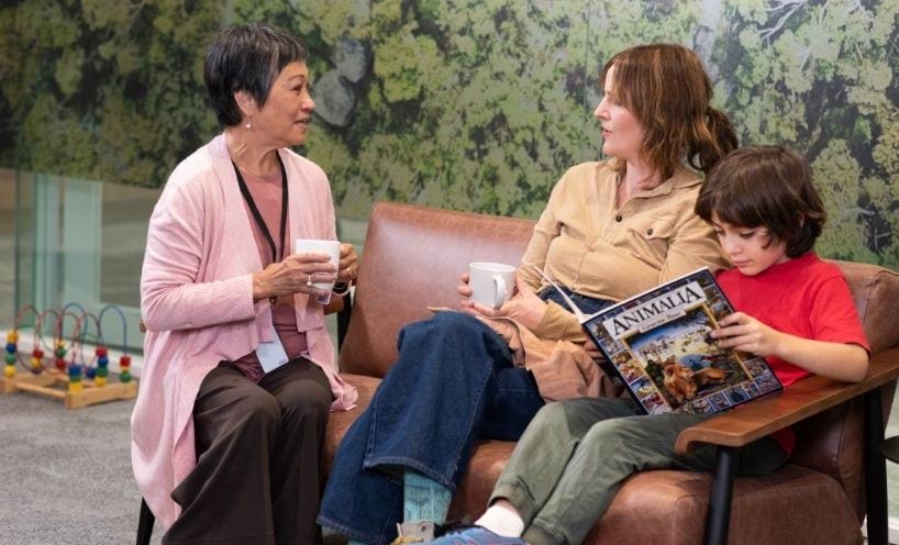 Two people and a child sitting and talking on a couch Two people and a child sitting and talking on a couch