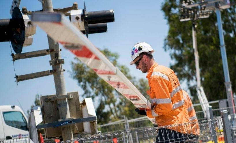 Worker in high-vis clothing operating a boom gate Worker in high-vis clothing operating a boom gate
